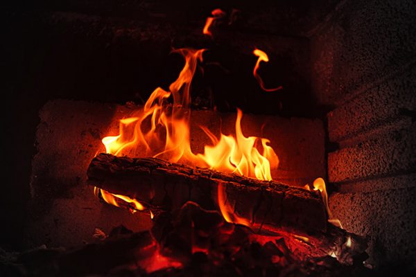 Burning wood in brick fireplace.