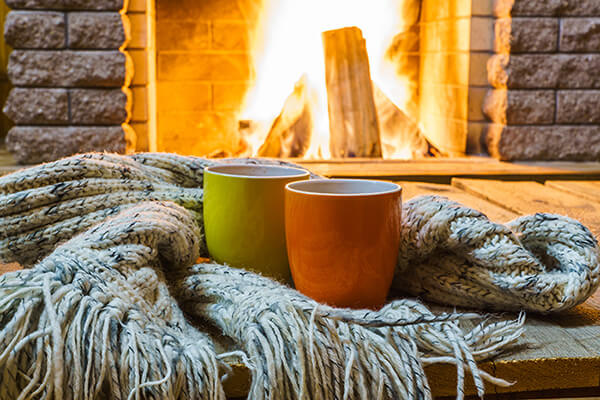 Two mugs in front of fireplace.