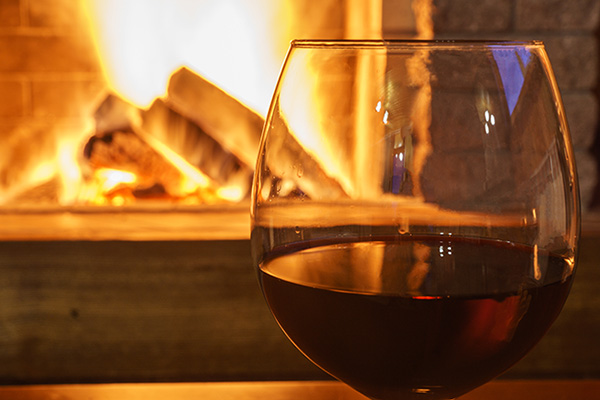 Cozy fireplace with glass of wine.