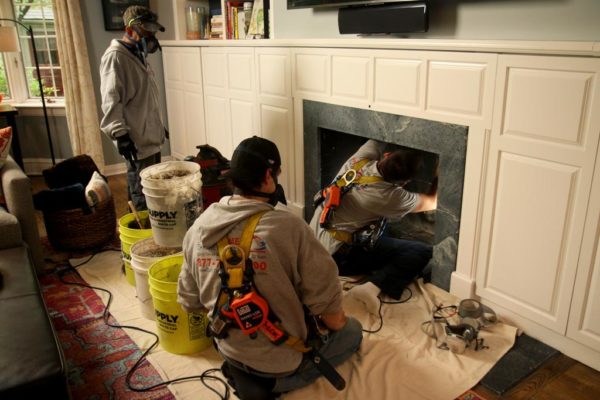 Crew doing fireplace maintenance.